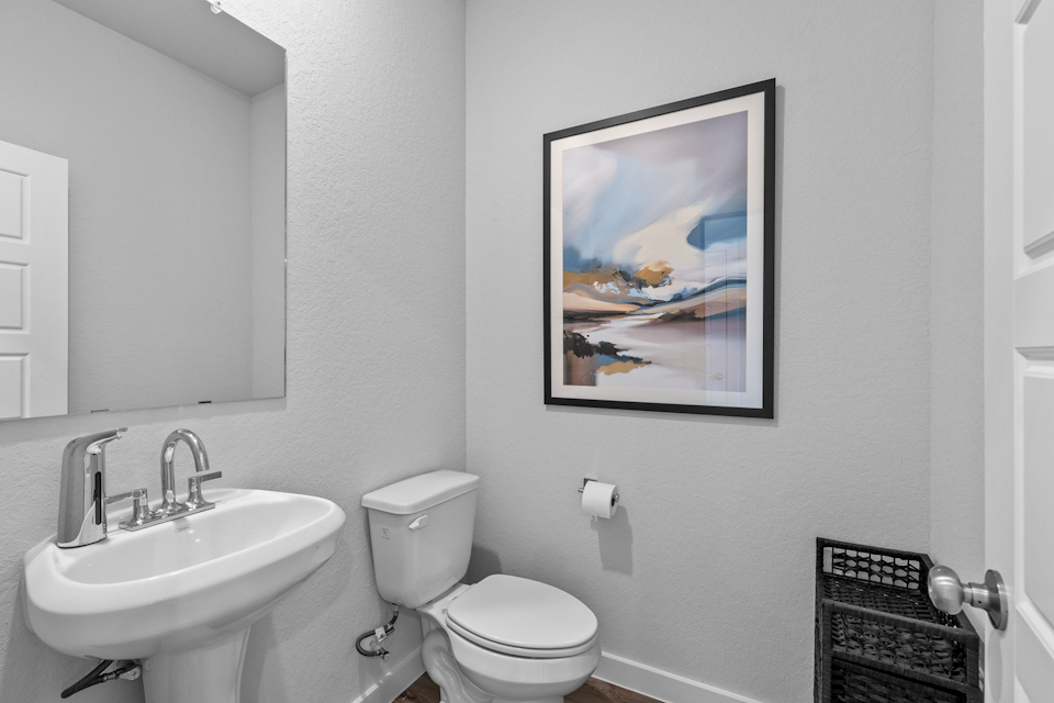 A bathroom with a picture on the wall.