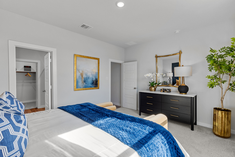 A bedroom with a bed and a dresser.