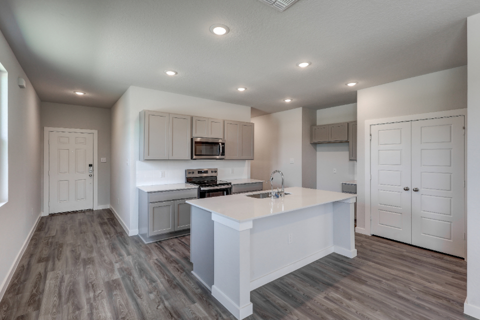 A kitchen with white cabinets.