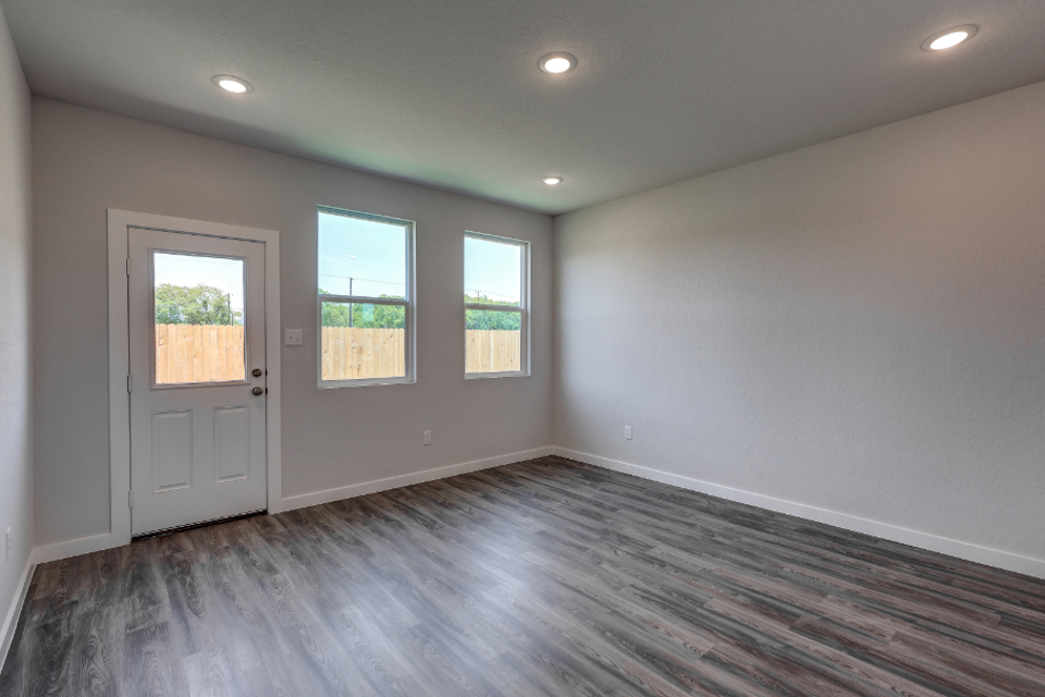 A room with a wood floor and windows.
