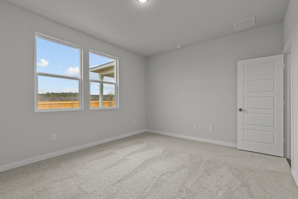 A room with a window and a door with a view of the water.