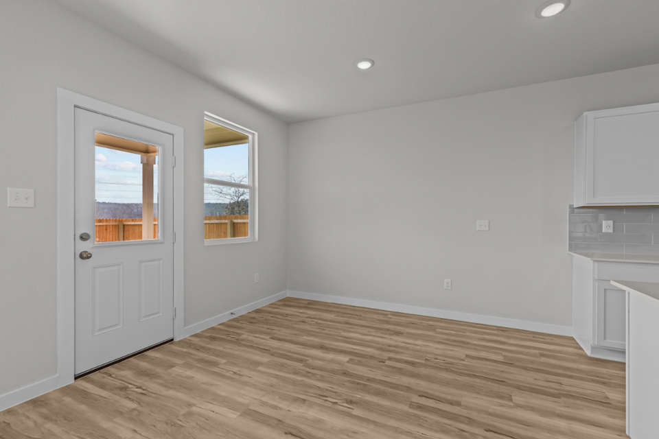 A room with a wood floor and a white door.