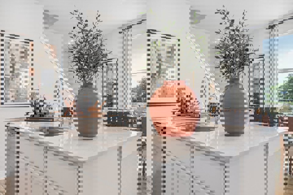 A kitchen with a vase of flowers.