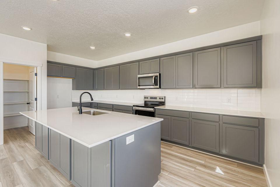 A kitchen with white cabinets.