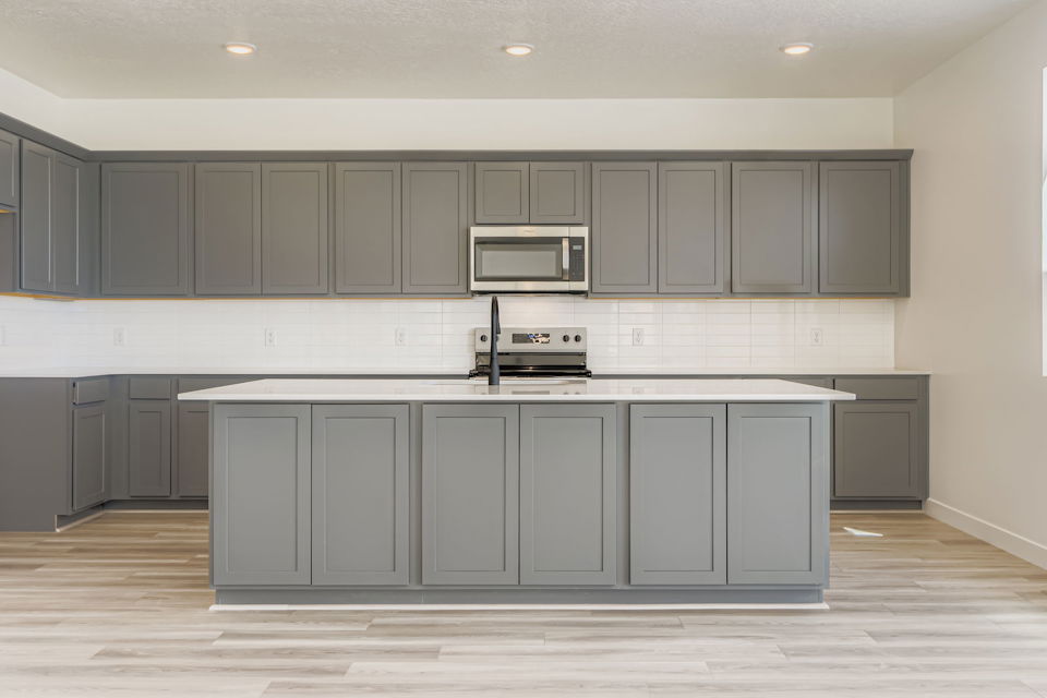 A kitchen with white cabinets.