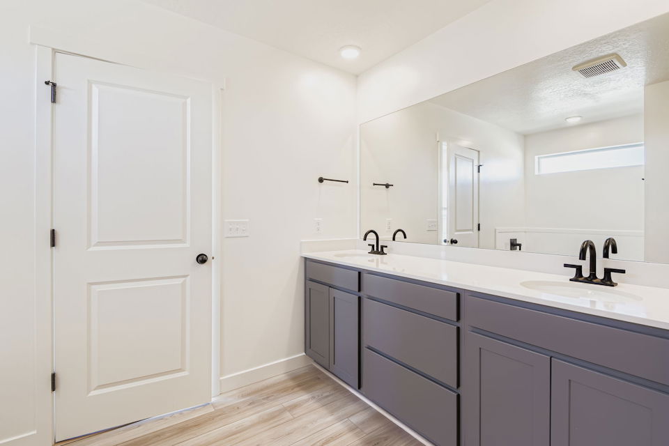 A bathroom with white cabinets.