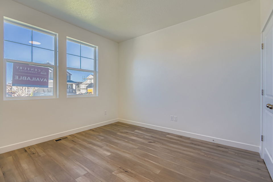 A room with a wood floor and windows.