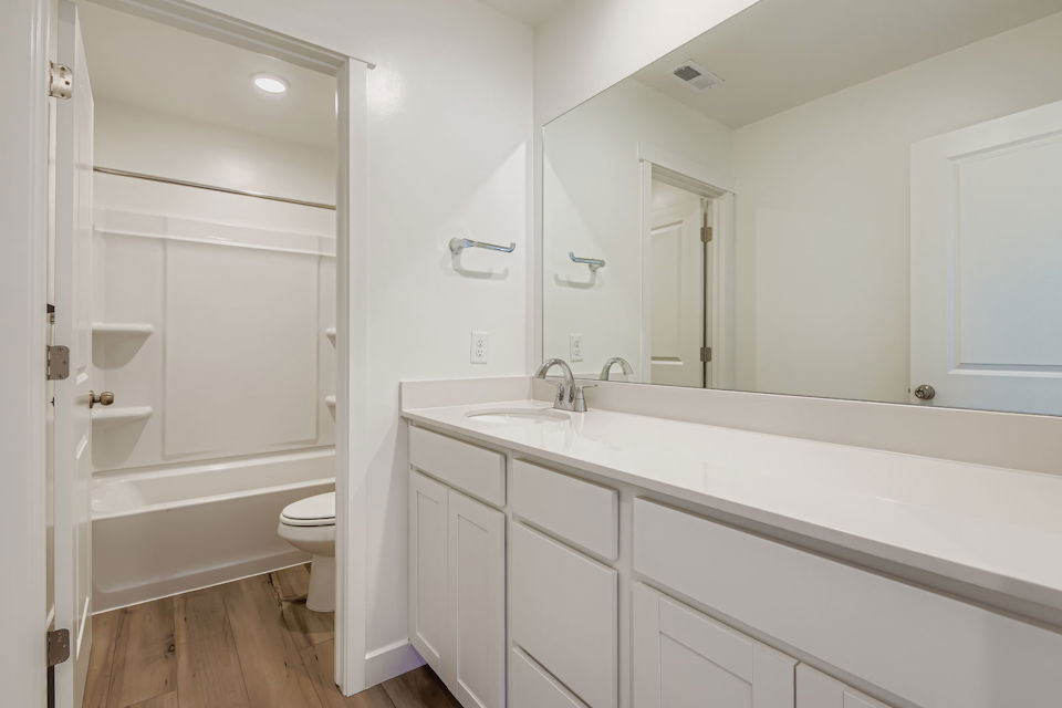 A bathroom with a tub sink and toilet.