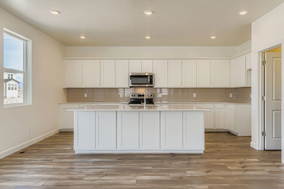 A kitchen with white cabinets.
