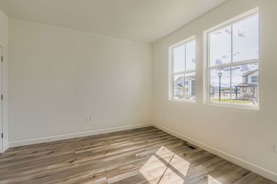 A room with windows and a wood floor.