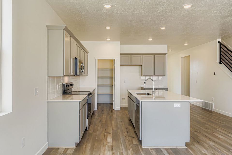 A kitchen with white cabinets.