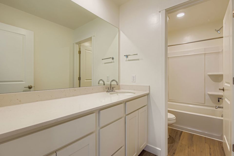 A bathroom with a tub sink and toilet.