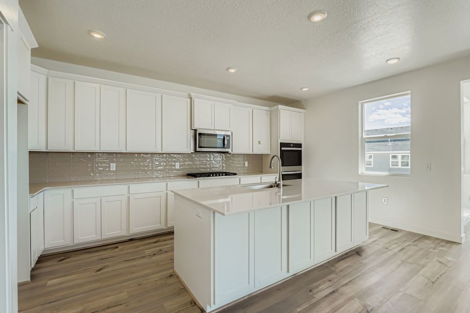 A kitchen with white cabinets.