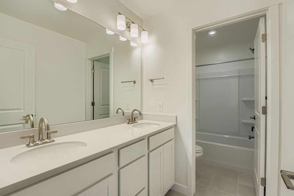 A bathroom with a sink and a shower unit.