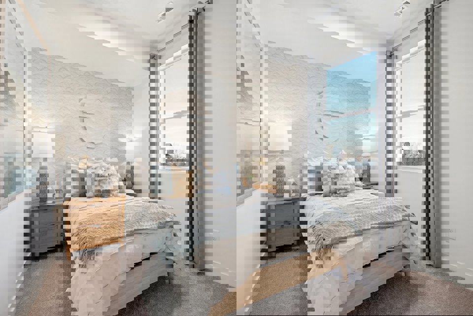 A bedroom with a large window.