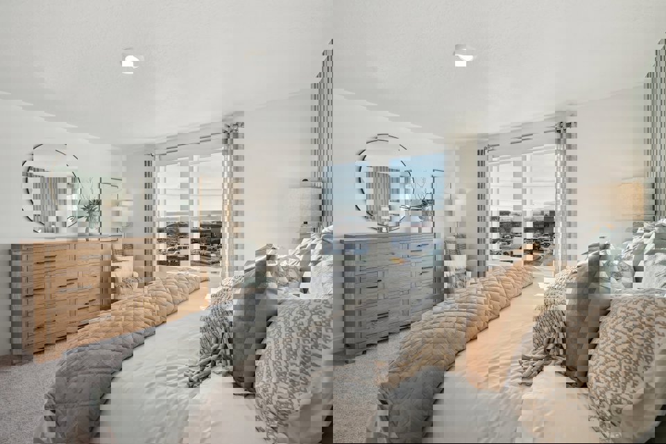 A bedroom with a large window.