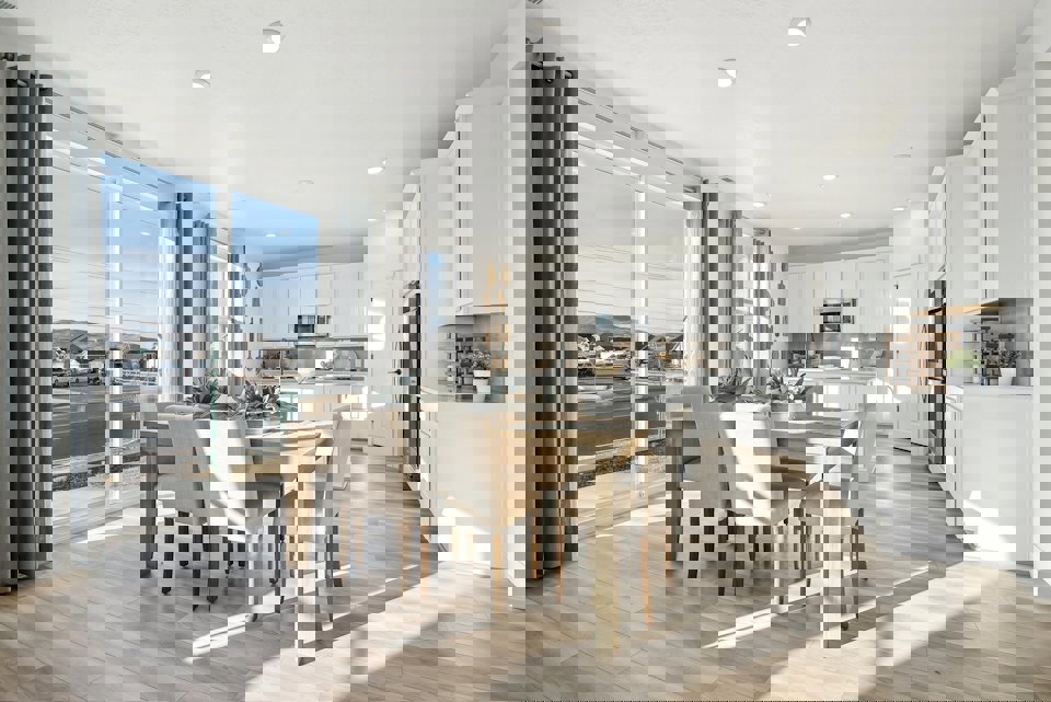 A kitchen with a dining table and chairs.