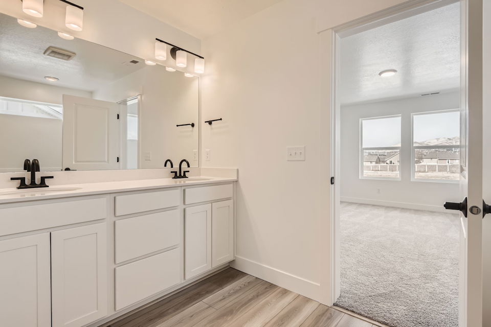 A bathroom with white cabinets.