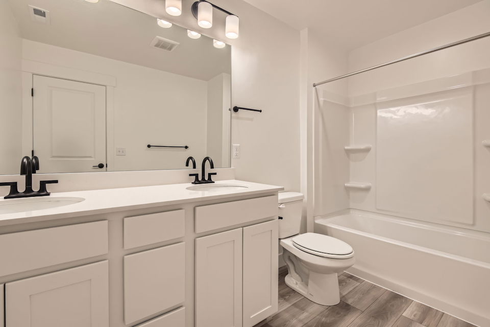 A bathroom with a tub toilet and sink.