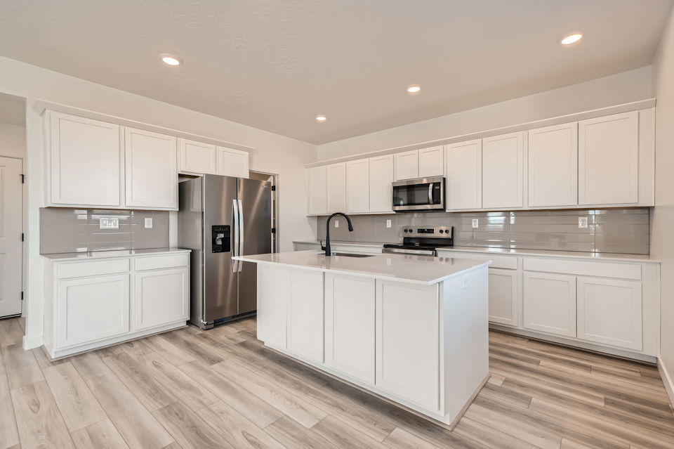 A kitchen with white cabinets.