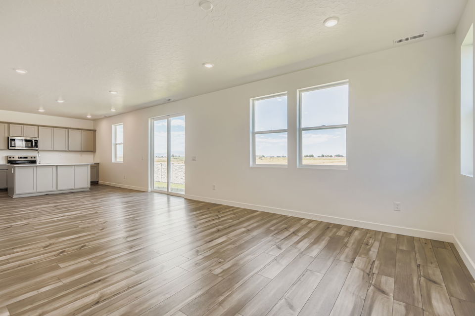 A large empty room with a wood floor and white walls.