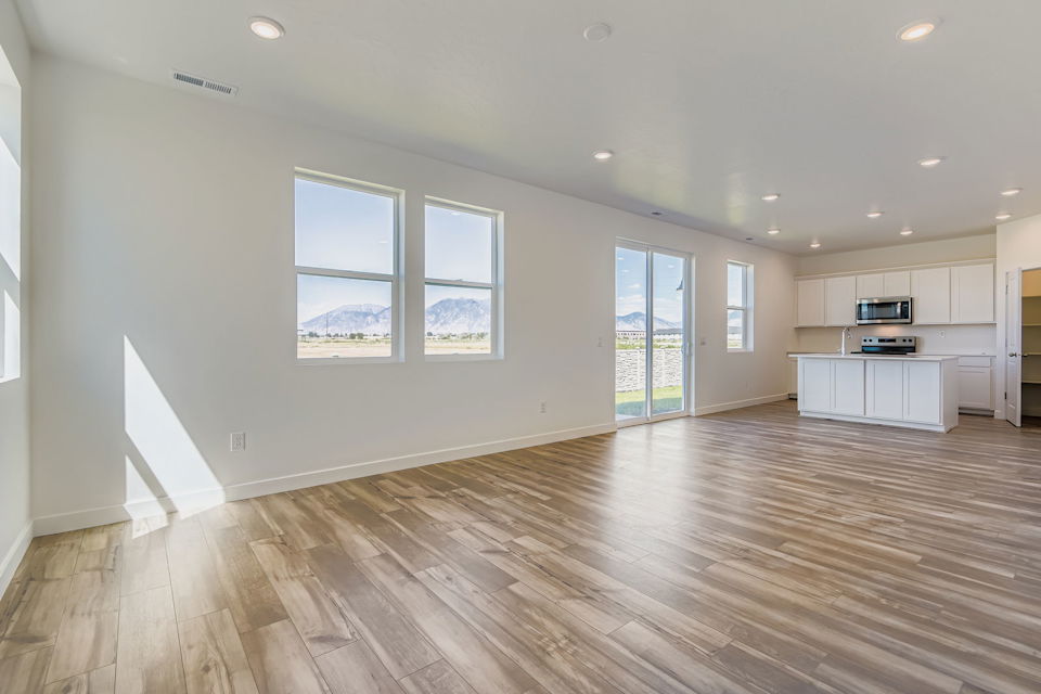 A large empty room with a wood floor and a wood floor.
