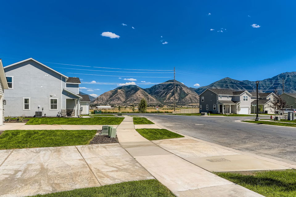 A road with houses and mountains in the background.