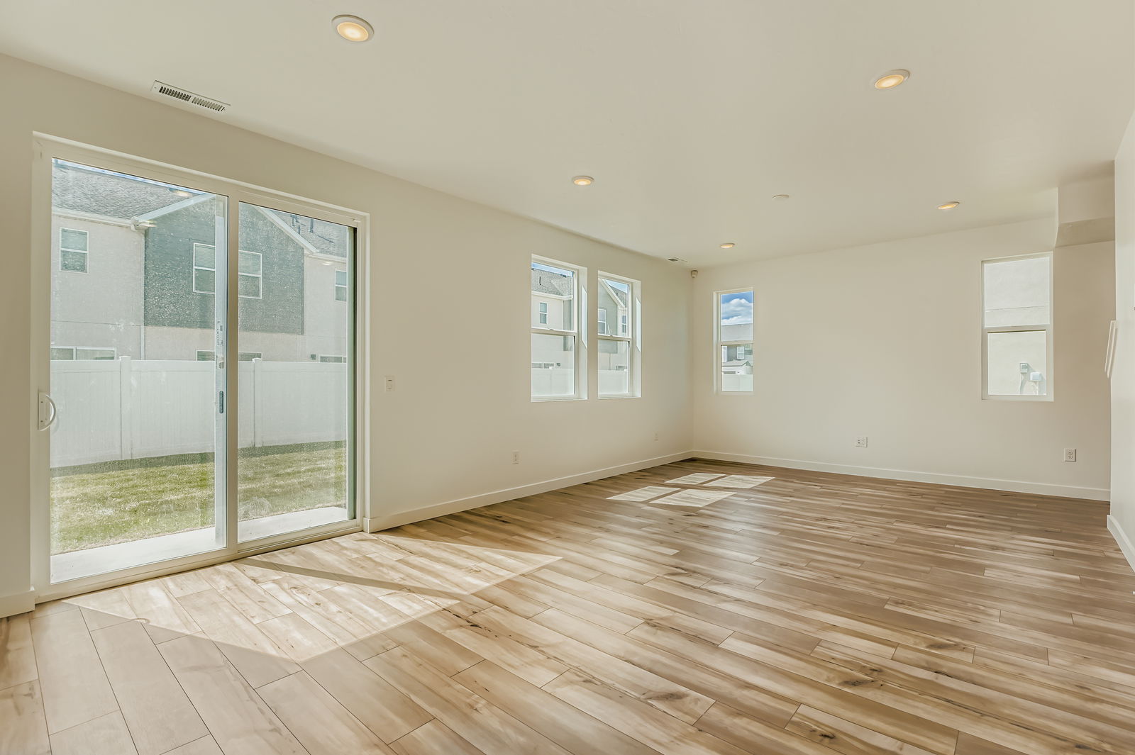 A room with a wood floor and glass doors.