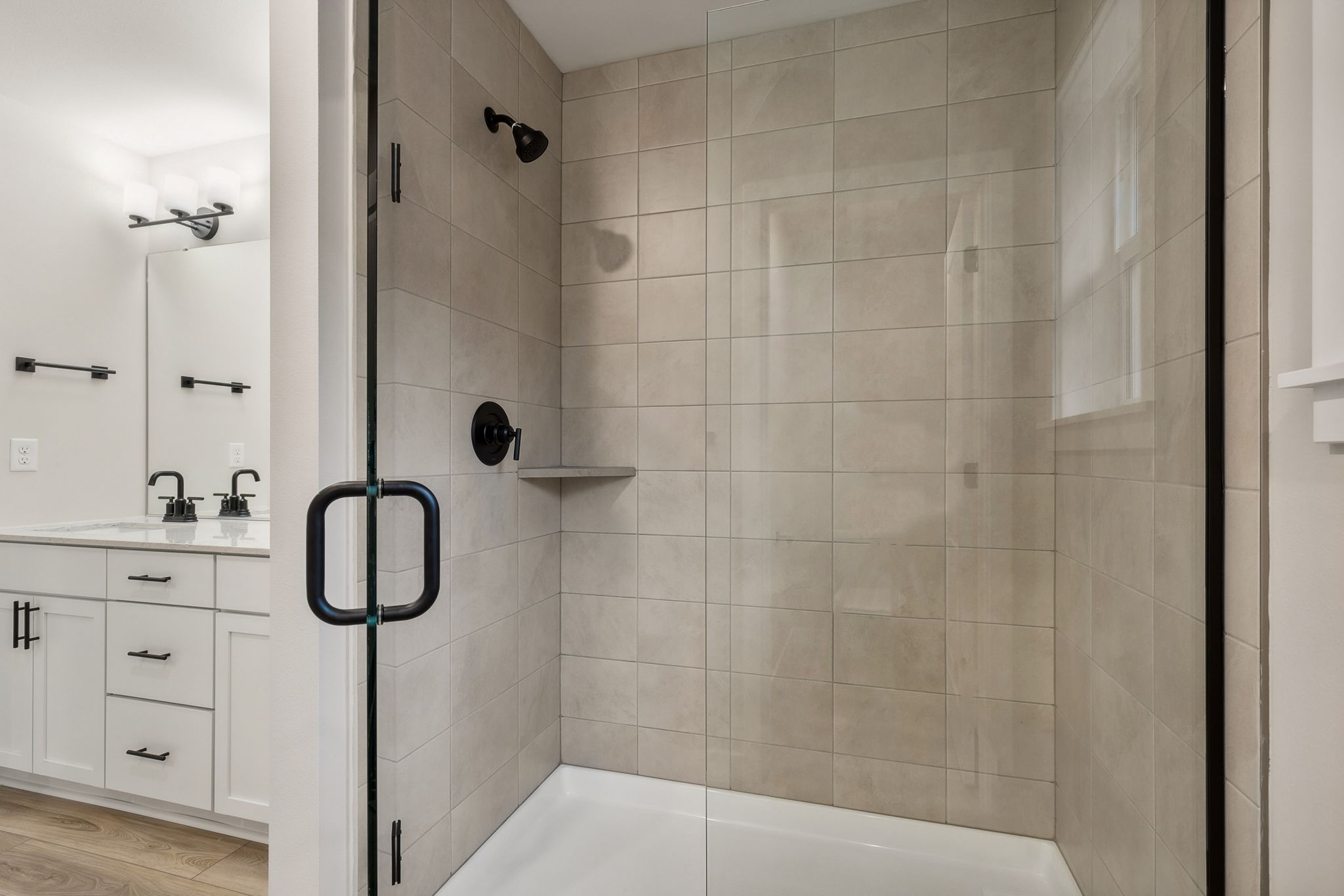 A bathroom with a shower unit and sink.
