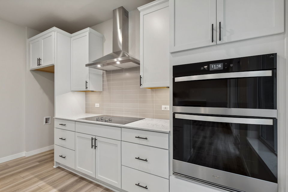 A kitchen with white cabinets.