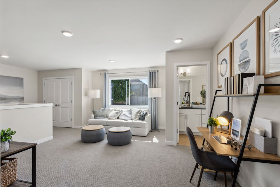 A living room with a couch and a desk.