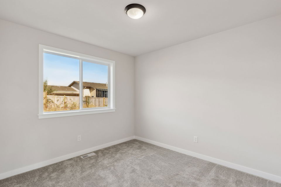 A room with a window and a carpet.