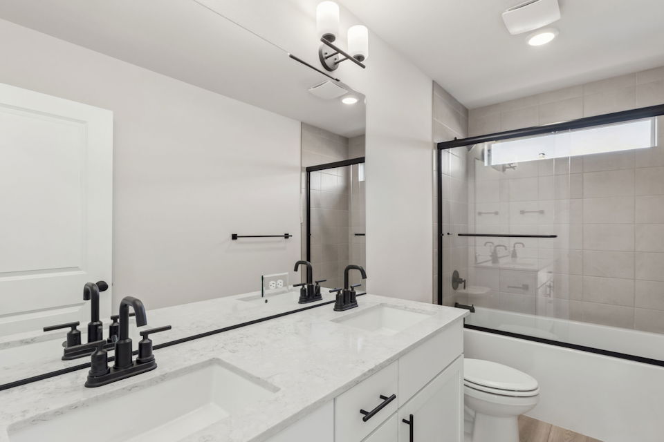 A bathroom with a tub sink and toilet.