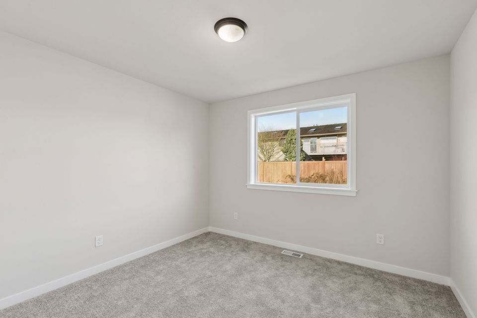 A room with a window and carpet.