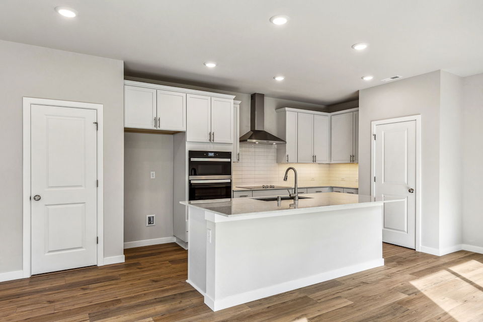 A kitchen with white cabinets.