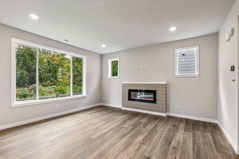 A room with a fireplace and a wood floor.