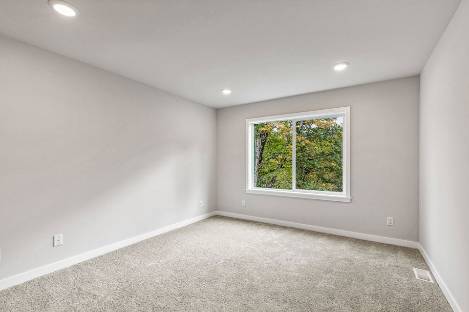 A room with a window and a carpet.