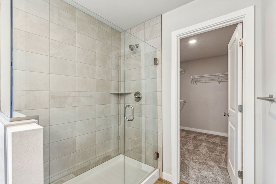 A bathroom with a shower unit and a bathtub.
