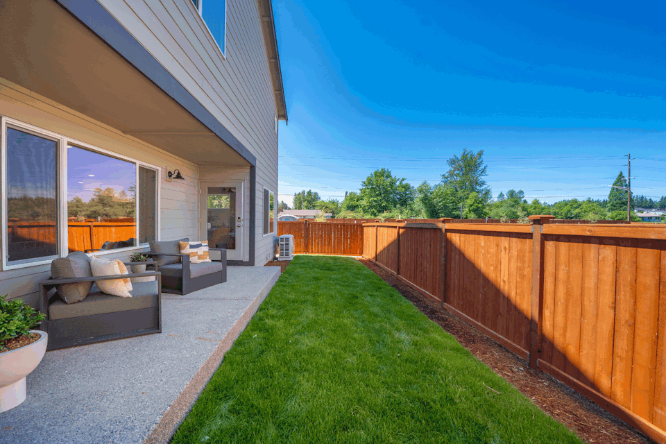 A backyard with a fence and a wood fence.