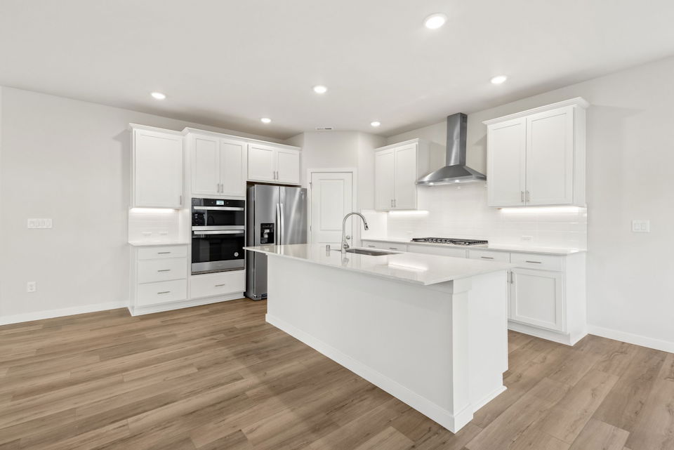 A kitchen with white cabinets.
