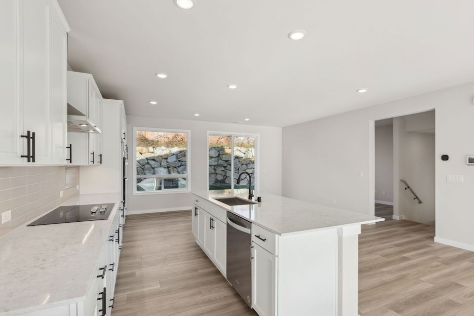 A kitchen with white cabinets.
