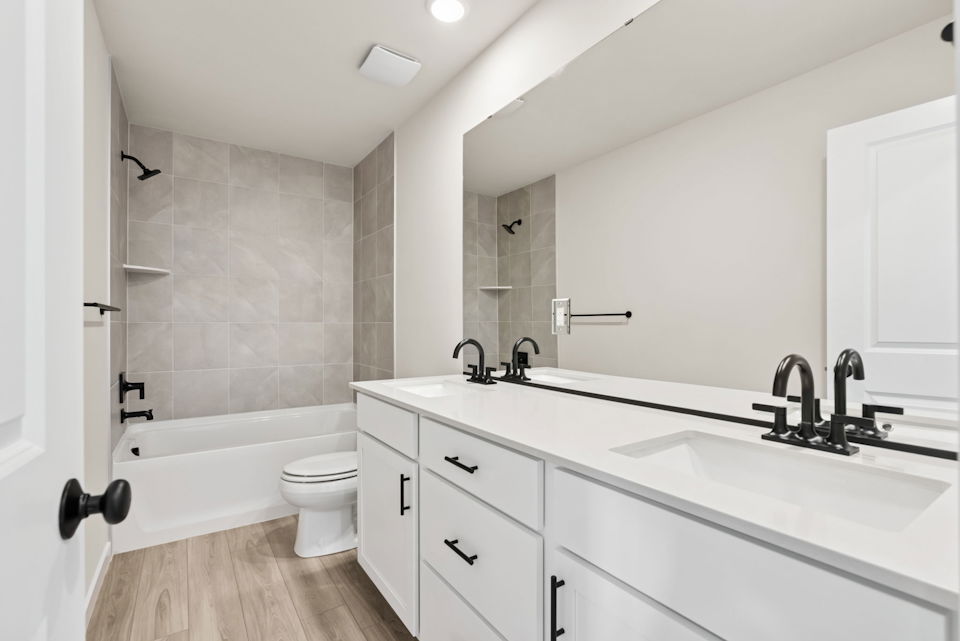 A bathroom with a tub sink and toilet.