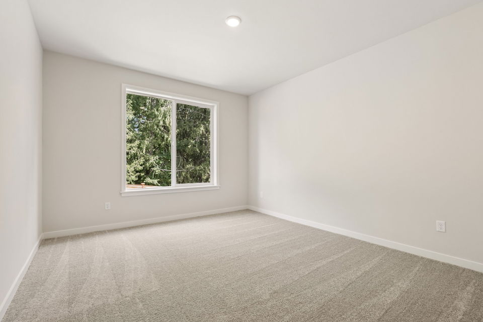A room with a window and a carpet.