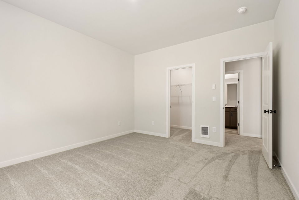 A room with a carpet and a door.