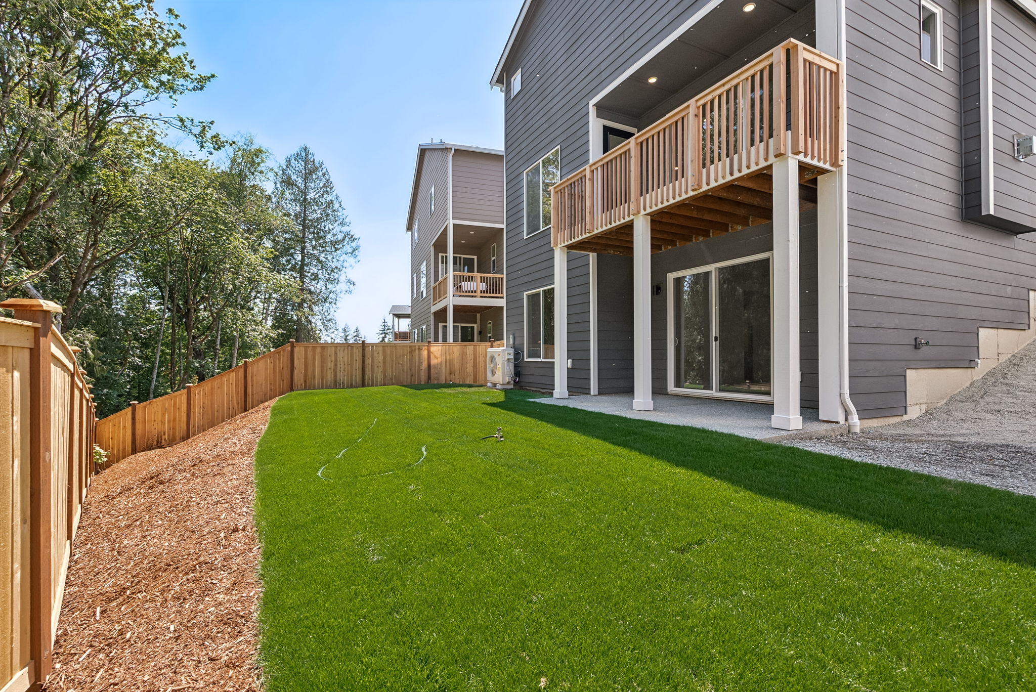 A backyard with a fence and a house.
