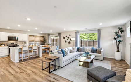 A large living room with a large kitchen and a large window.