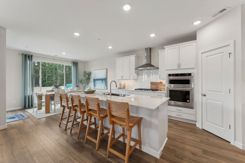 A kitchen with a dining table and chairs.