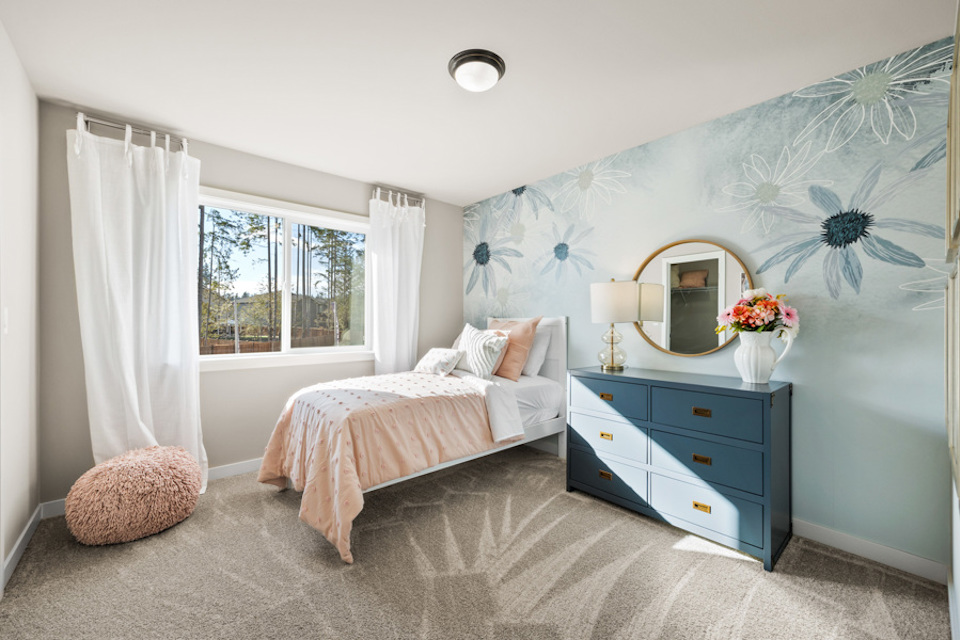 A bedroom with a bed and a dresser.