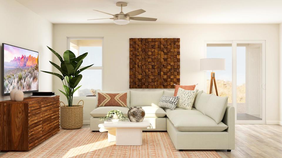A living room with a white couch and a fan.