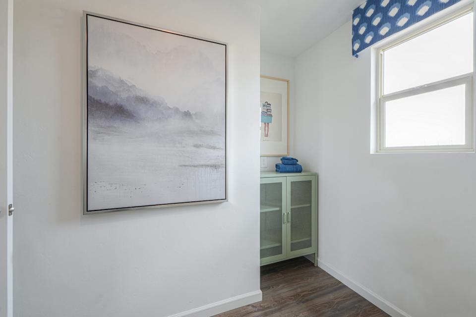 A room with a picture on the wall.